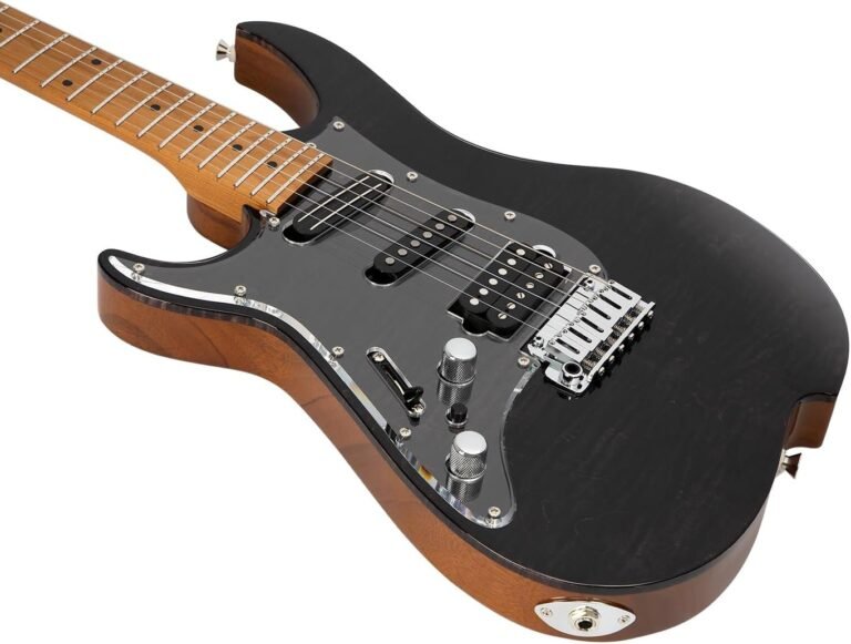 Left-handed electric guitar beside a recording setup at home