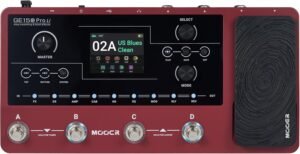 A vibrant plum-colored guitar multi effects pedal with four footswitches and a built-in expression pedal on a rehearsal room floor.